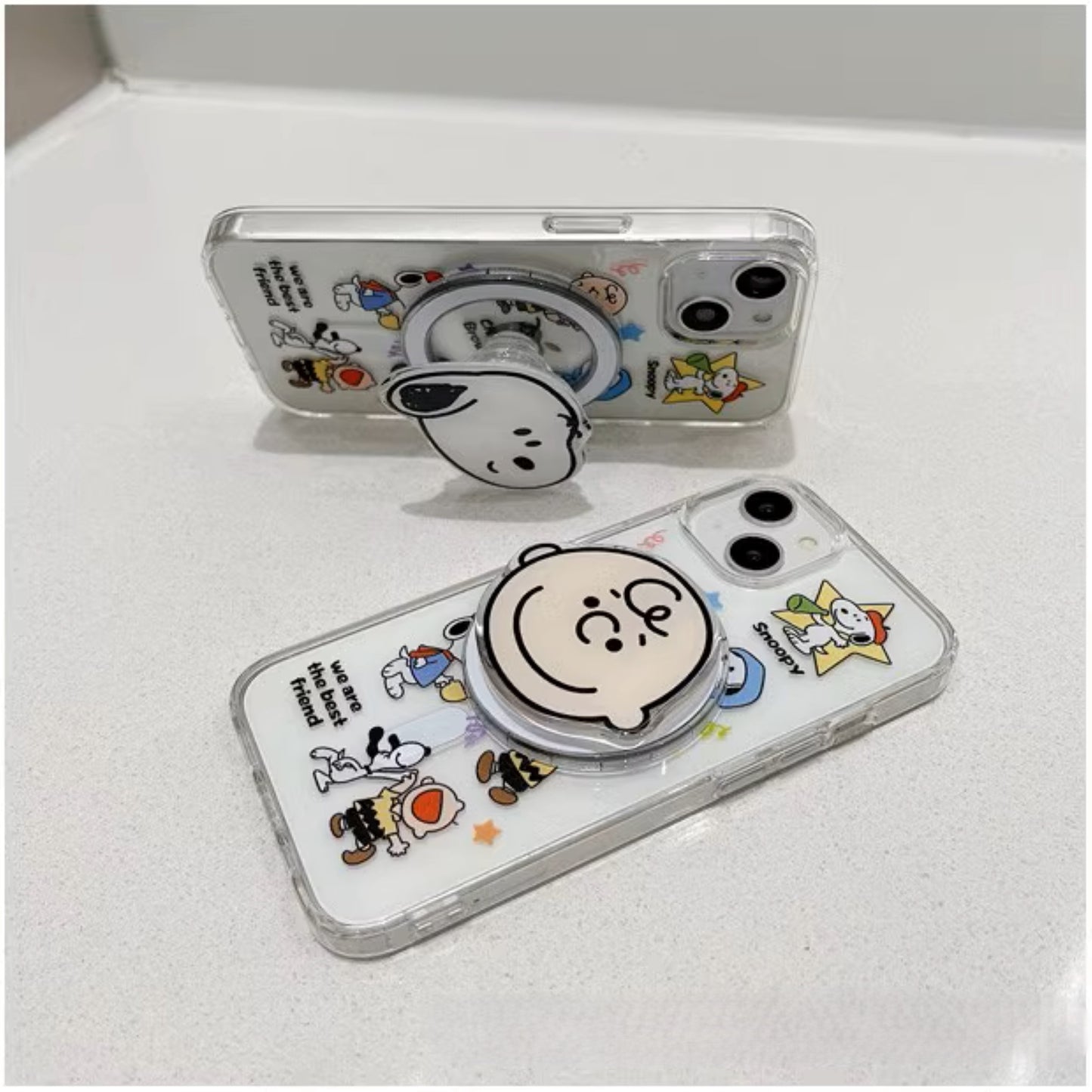 Snoopy Clear Companions MagSafe iPhone case with popsocket, featuring iconic Peanuts characters in a transparent design, enhancing phone grip and style."