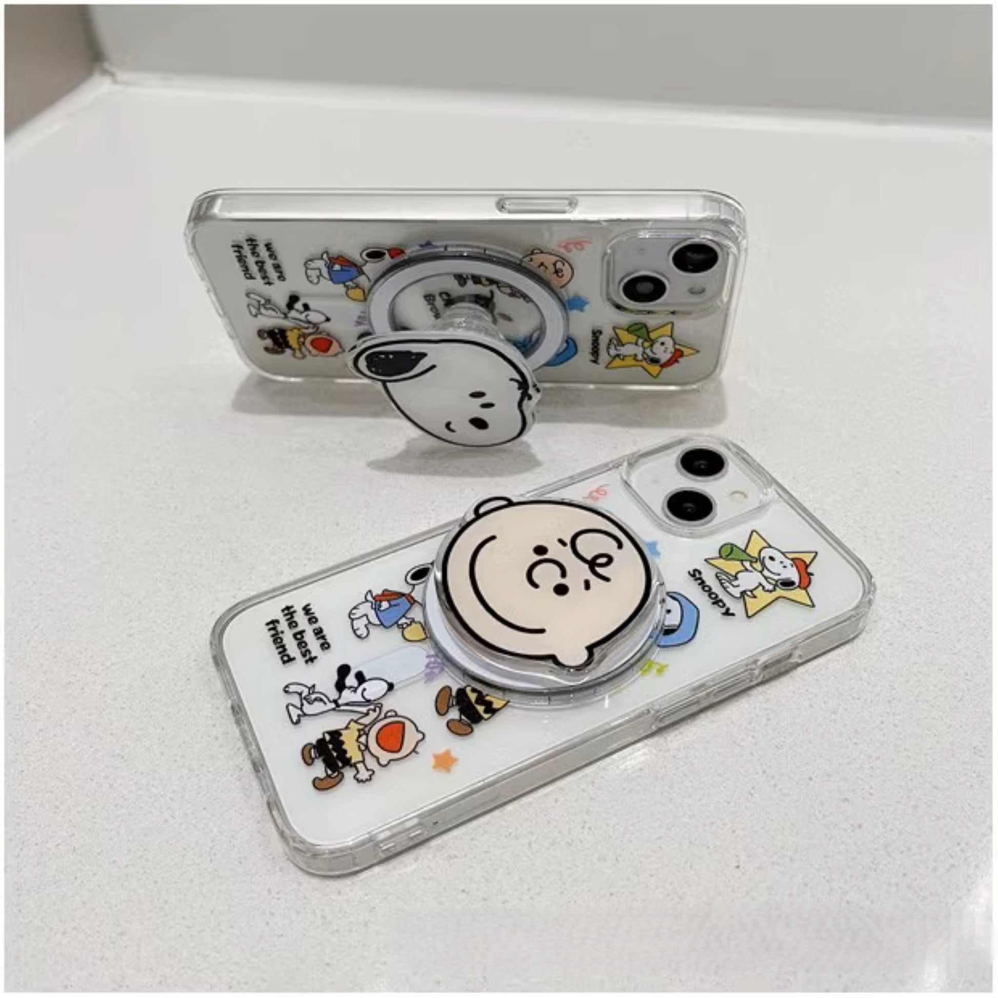 Snoopy Clear Companions MagSafe iPhone case with popsocket, featuring iconic Peanuts characters in a transparent design, enhancing phone grip and style."