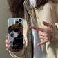 iPhone case. Original design iPhone cases with dog illustrations. Half-covered, super slim & lightweight phone case. Hard polycarbonate material. Women holding front view.