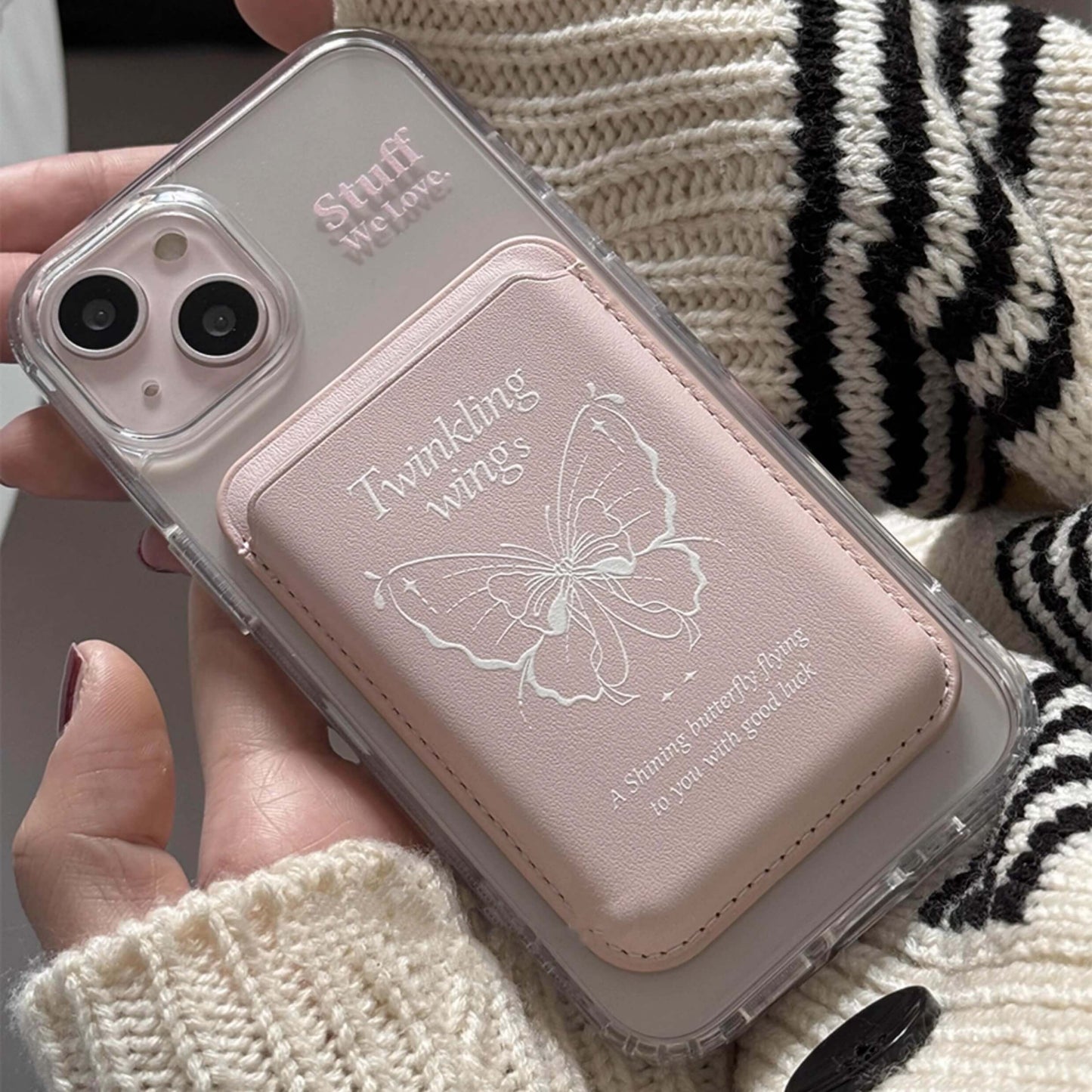 Pink MagSafe phone cases, attached by Magsafe wallet with pink based and reach with an embossed butterfly and 'Twinkling wings' text, symbolizing good luck, set against a clear case background