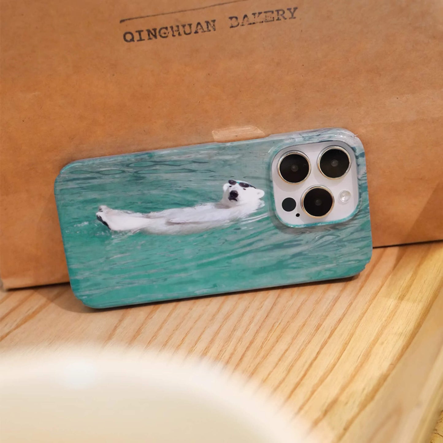 iphone case featuring polar bear chill and lying on blue sea, side view