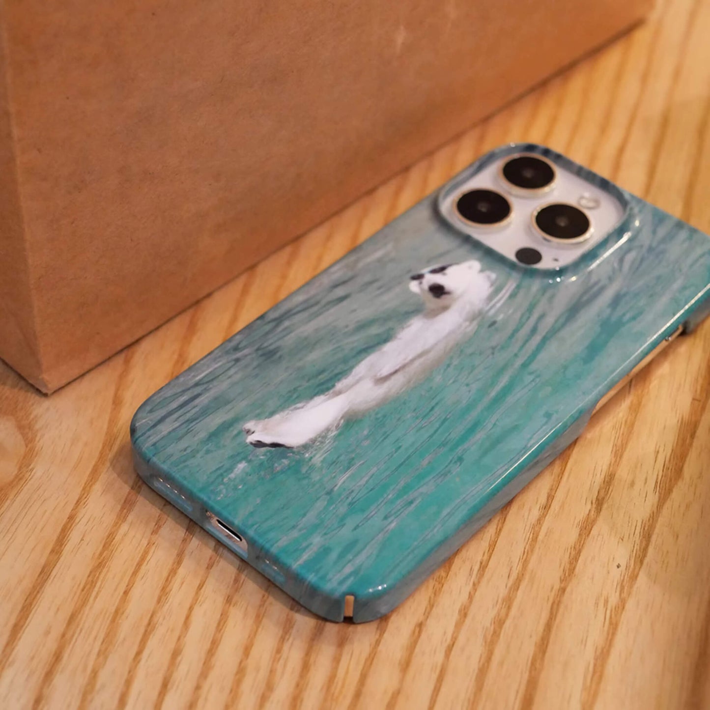 iphone case featuring polar bear chill and lying on blue sea, bottom view